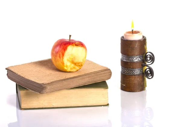 Old books, apple and a candle — Stock Photo, Image