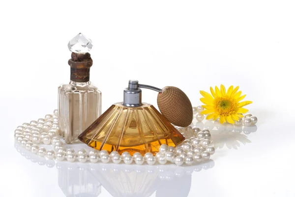 Parfümflaschen Perlen & gelbe Blume lizenzfreie Stockfotos