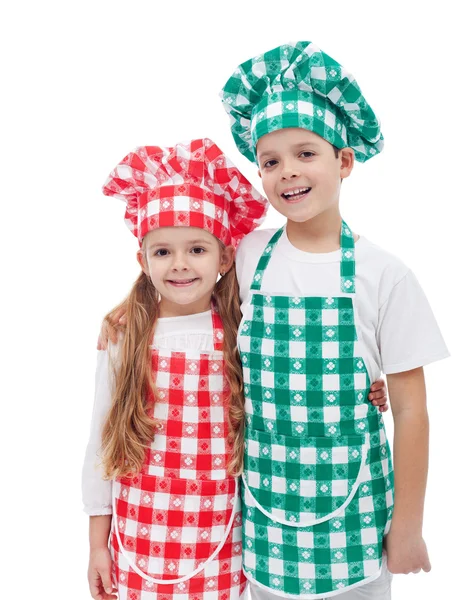 Chefs felizes - menino e menina com aventais e chapéus — Fotografia de Stock