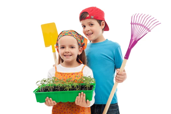Kinder mit Frühlingssetzlingen und Gartengeräten — Stockfoto