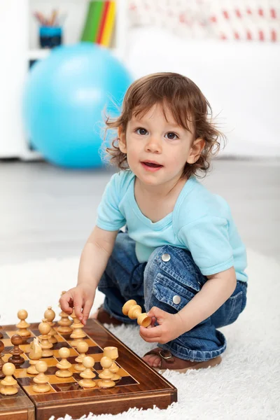 Adorabile bambino che gioca con i pezzi degli scacchi — Foto Stock