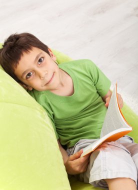 Young boy reads a book clipart