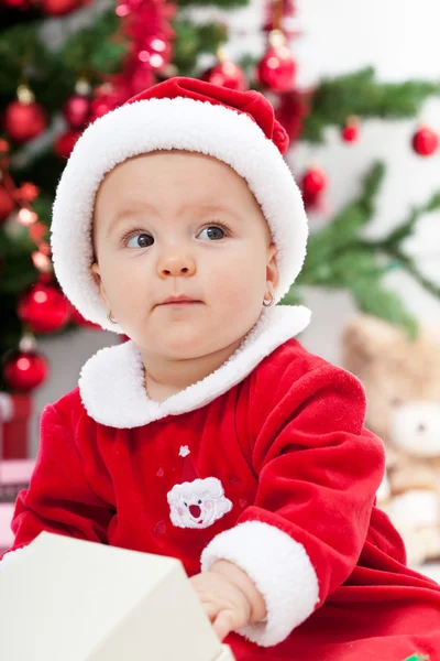 Baby girl and christmas tree - close seup — стоковое фото