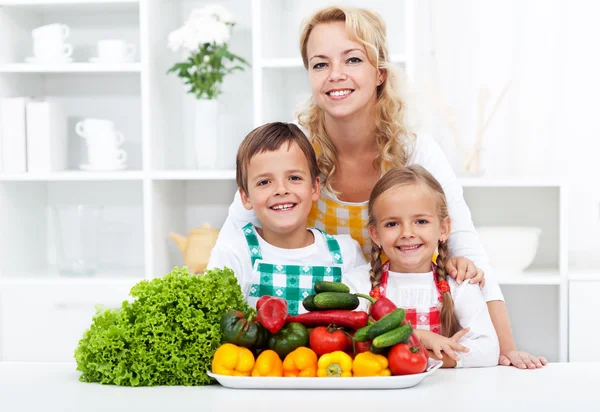 Γυναίκα και τα παιδιά με λαχανικά στην κουζίνα — Φωτογραφία Αρχείου