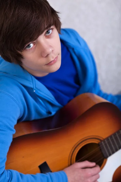 Мальчик-подросток играет на гитаре — стоковое фото