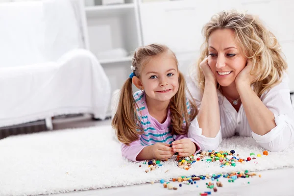 Making a necklace for mom - little girl playing — Stock Photo, Image