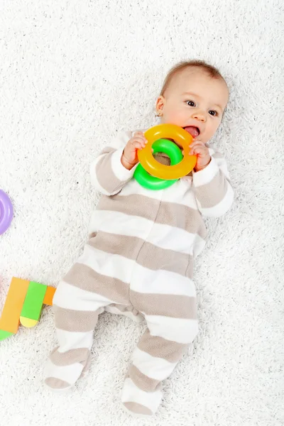 Baby flicka som leker på golvet tugga leksaker — Stockfoto