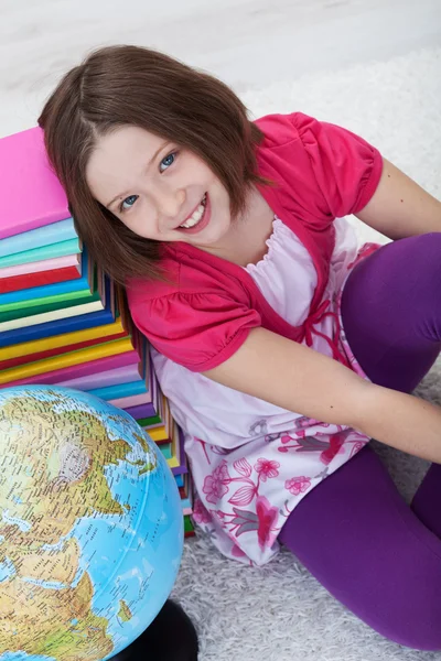 Щаслива школярка з книгами та глобусом — стокове фото