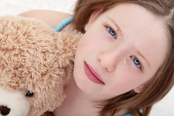 Oyuncak ayı tutarak ve ağlayarak hüzünlü kız — Stok fotoğraf