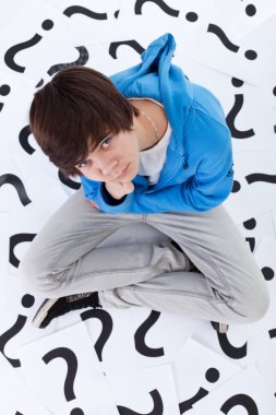 Young teenager boy with lots of questions clipart