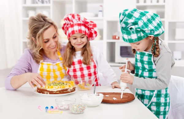 Mujer y sus hijas en la cocina — Foto de Stock