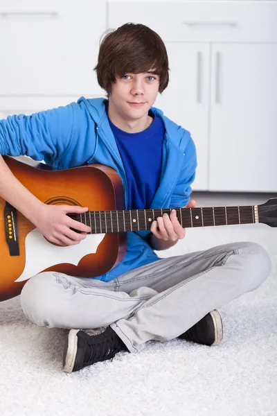 Молодий хлопчик-підліток грає на гітарі — стокове фото
