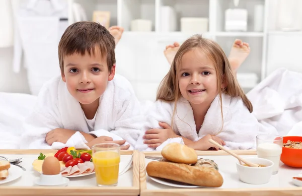 Τα παιδιά, έχοντας ένα υγιεινό πρωινό στο κρεβάτι — Φωτογραφία Αρχείου