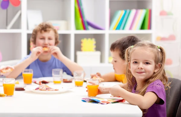 Niños alrededor de la mesa comiendo —  Fotos de Stock