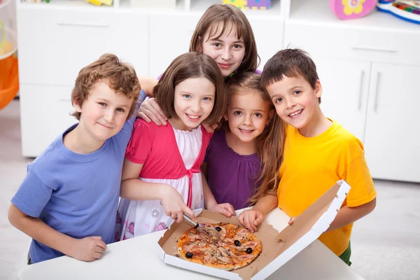 Děti doma s pizzou — Stock fotografie