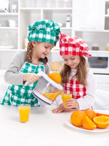 Meninas fazendo suco de laranja recentemente apertado — Fotografia de Stock