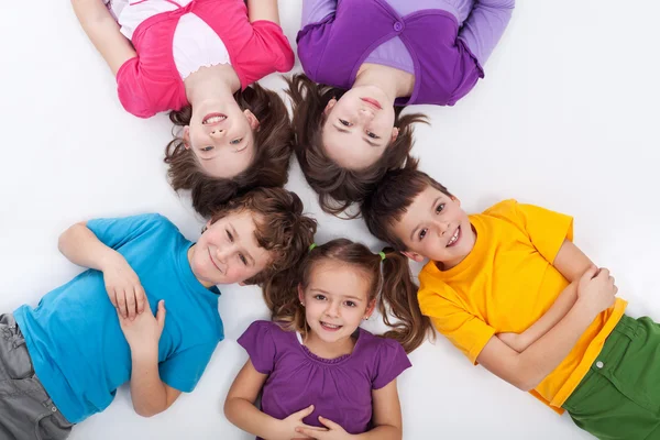 Cinco crianças felizes no chão — Fotografia de Stock