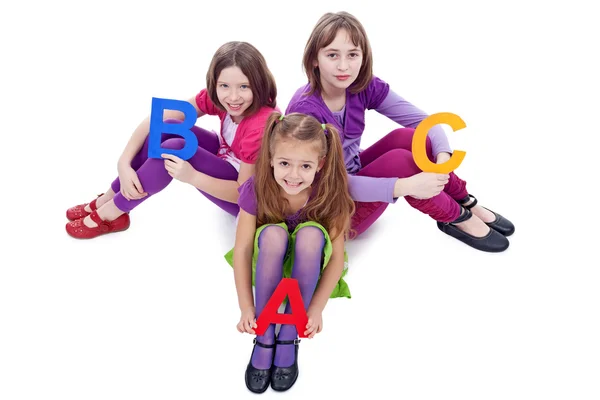 Jonge schoolmeisjes houden van brieven van abc — Stockfoto