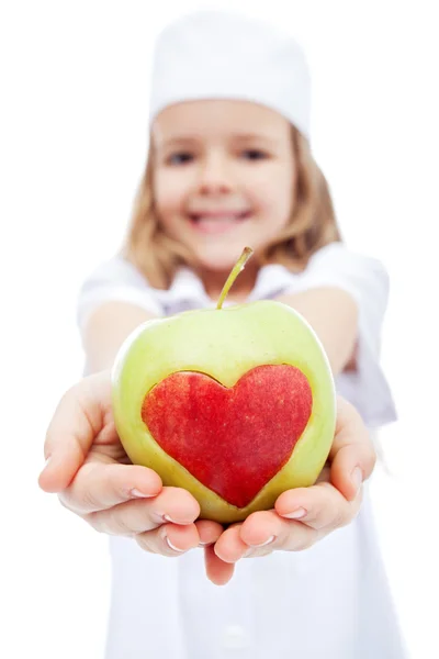 Маленькая девочка, как медсестра, дарит тебе яблоко — стоковое фото