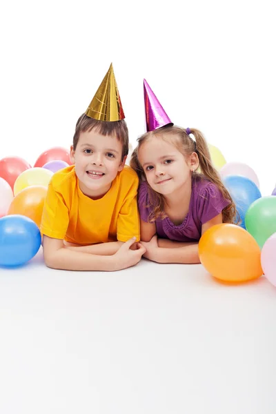 Дети в шляпах для вечеринок и воздушных шарах — стоковое фото