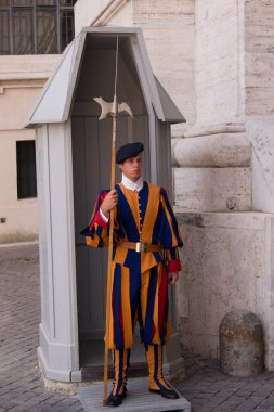 Soldier of Vatican Swiss Guard staying in front of the guardhouse in Vatican, Italy. clipart