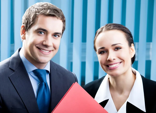Two happy businesspeople with folder at office Royalty Free Stock Images