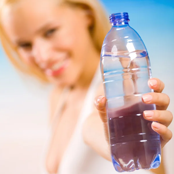 Mujer con botella de agua en la playa — Foto de Stock