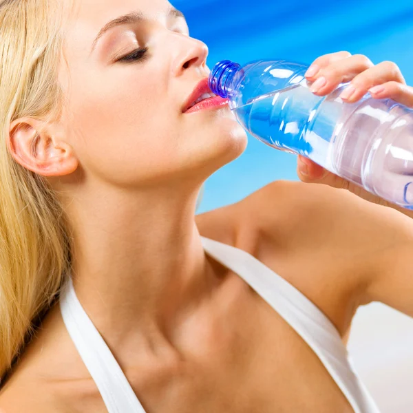 Mujer con botella de agua en la playa — Foto de Stock