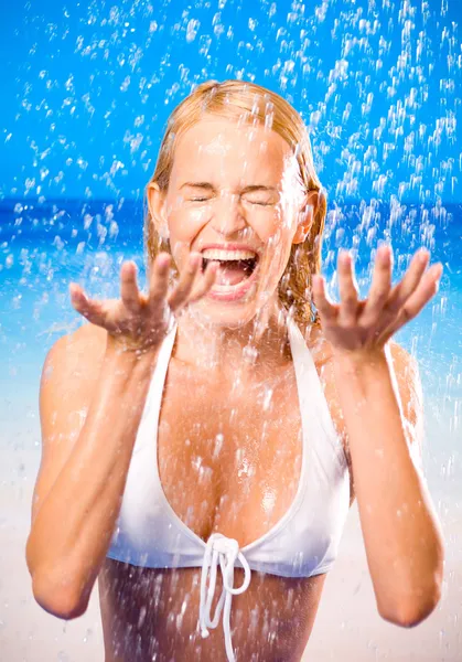 Young woman at rain or summer shower on beach — Stock Photo, Image