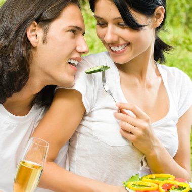 Young happy couple at picnic, outdoors clipart