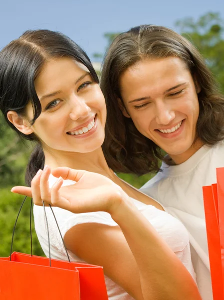 Jovem casal com sacos de compras, ao ar livre — Fotografia de Stock