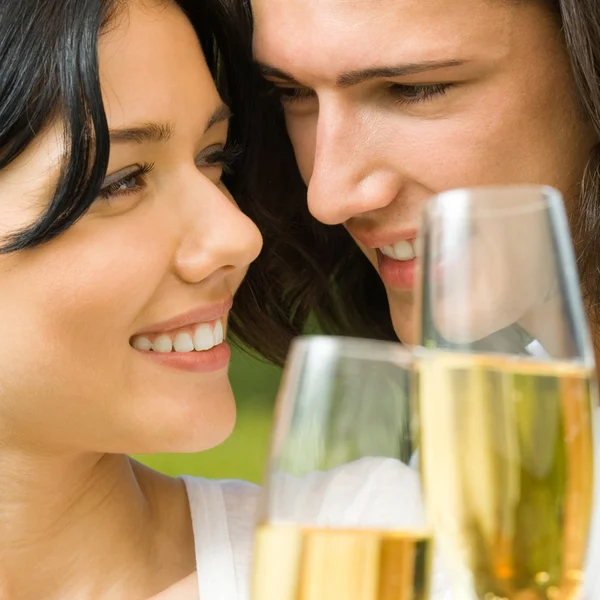Молодая счастливая пара с шампанским, на открытом воздухе — стоковое фото