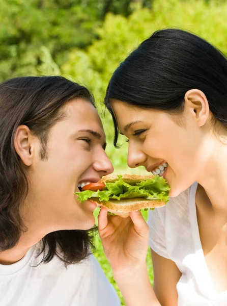 Jeune couple manger ensemble à l'extérieur — Photo