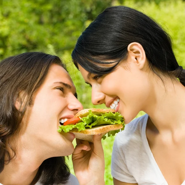 Giovane coppia mangiare insieme all'aperto — Foto Stock