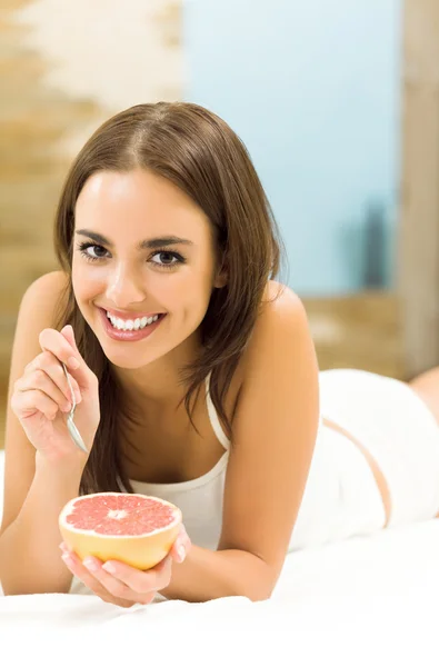 Young woman with grapefruit at home — Stock Photo, Image
