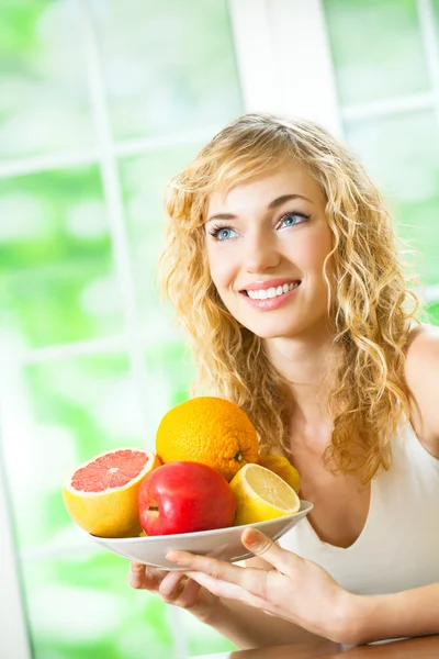 Donna con piatto di frutta, al chiuso — Foto Stock