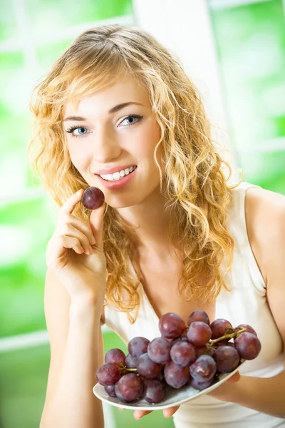 Mladá žena s hroznovým vínem, doma — Stock fotografie