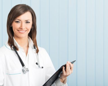 Smiling female doctor with clipboard at office clipart