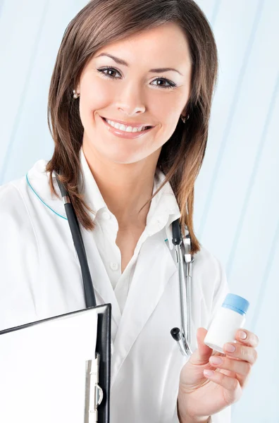 Female doctor with drug and clipboard at office — Stock Photo, Image