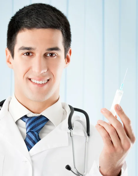 Šťastný doktor s injekční stříkačkou v kanceláři — Stock fotografie