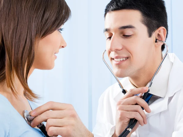 Doktor s stetoskop a pacient v kanceláři — Stock fotografie