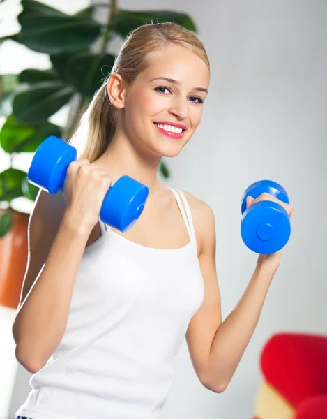 Woman exercising with dumbbells, at home — Stockfoto