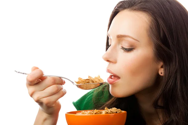Woman eating muesli or corn flakes, on white — Stock Photo, Image