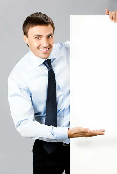 Affärsman som visar skylt, på grå — Stockfoto