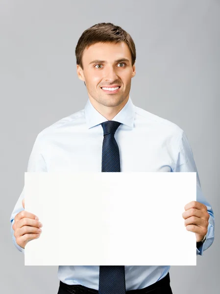 Uomo d'affari che mostra cartello, su grigio — Foto Stock