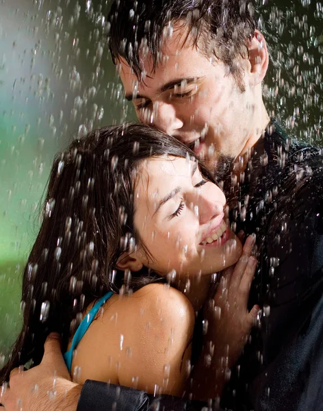 Jovem casal abraçando sob uma chuva — Fotografia de Stock