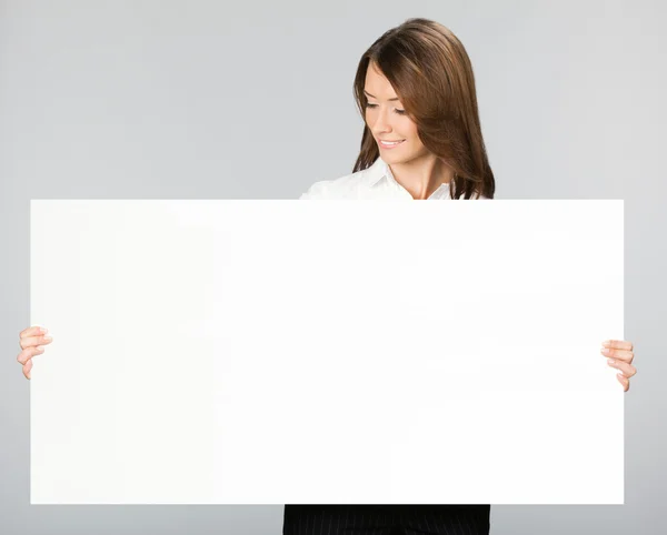 Businesswoman showing signboard, over grey — Stock Photo, Image