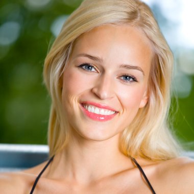 Smiling young beautiful woman, outdoors clipart