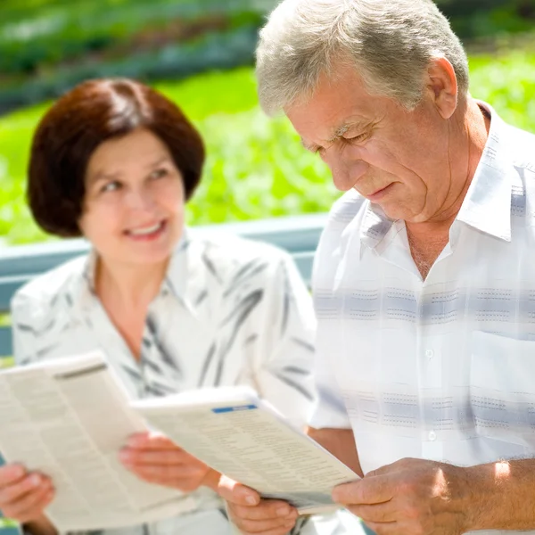 Gelukkige senior paar lezen buitenshuis — Stockfoto