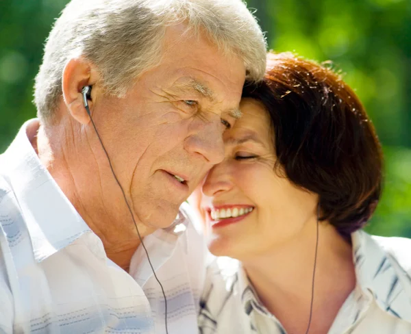 Senior koppel in hoofdtelefoon samen, buitenshuis — Stockfoto